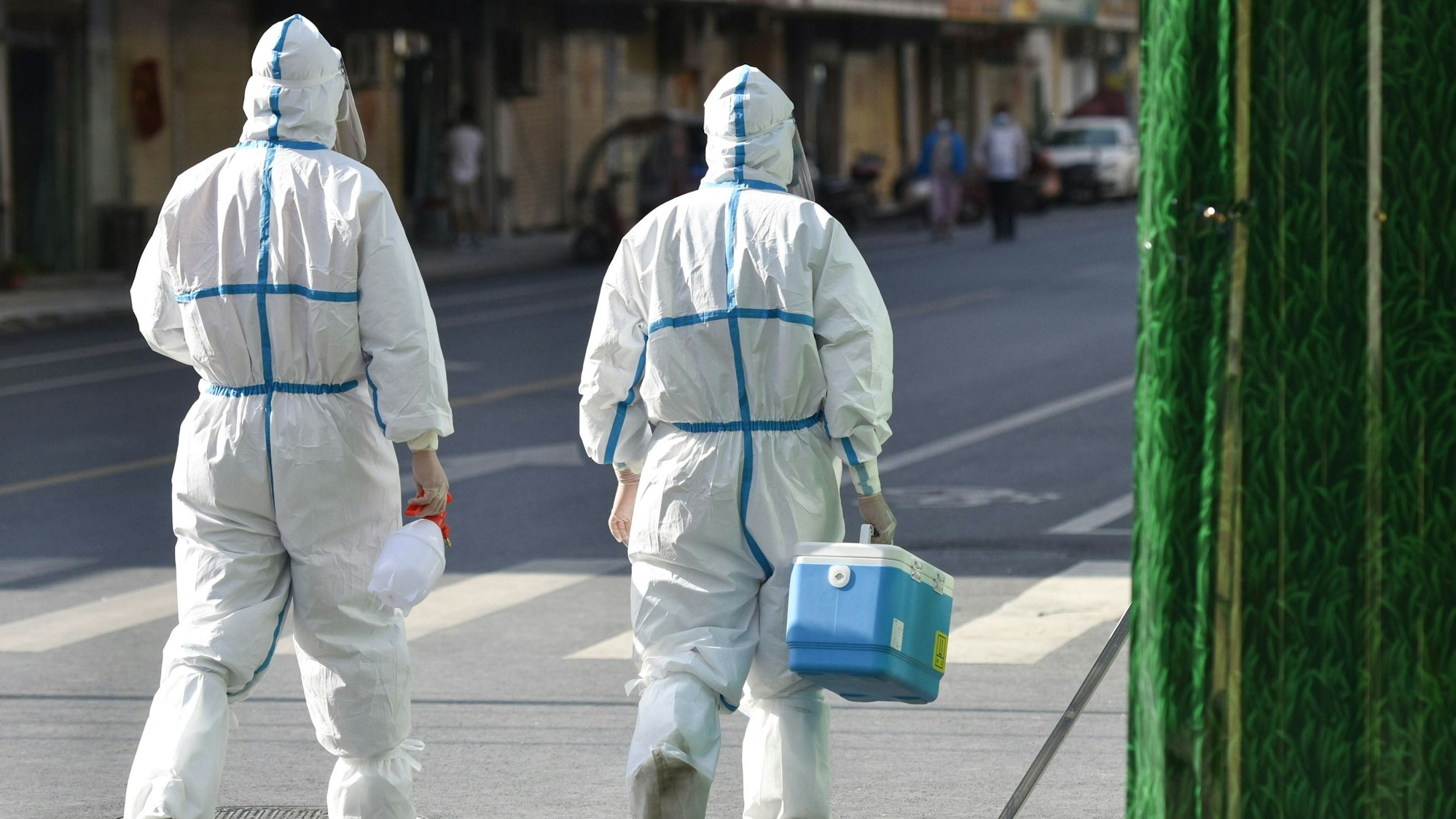 Medizinisches Personal in Schutzkleidung (PSA) geht am 9. April 2022 auf einer Straße in einem abgeriegelten Bereich. China verfolgt rigoros eine Null-Covid-Strategie und hat Shanghai abgeriegelt.