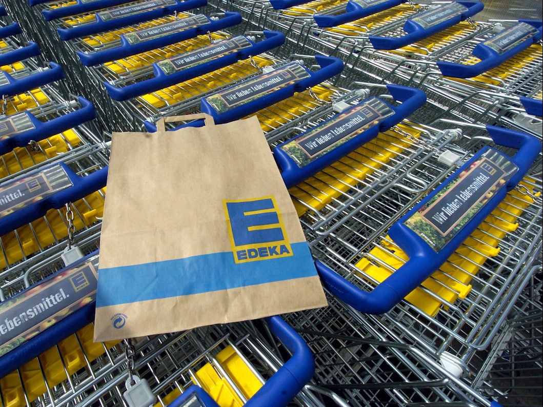 Das Symbolbild zeigt mehrere Einkaufswagen und eine Einkaufstüte des Supermarktes Edeka. Aufgenommen wurde das Bild am 28. April 2005.