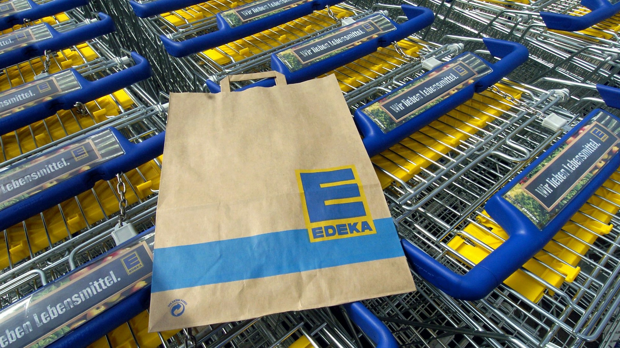 Das Symbolbild zeigt mehrere Einkaufswagen und eine Einkaufstüte des Supermarktes Edeka. Aufgenommen wurde das Bild am 28. April 2005.
