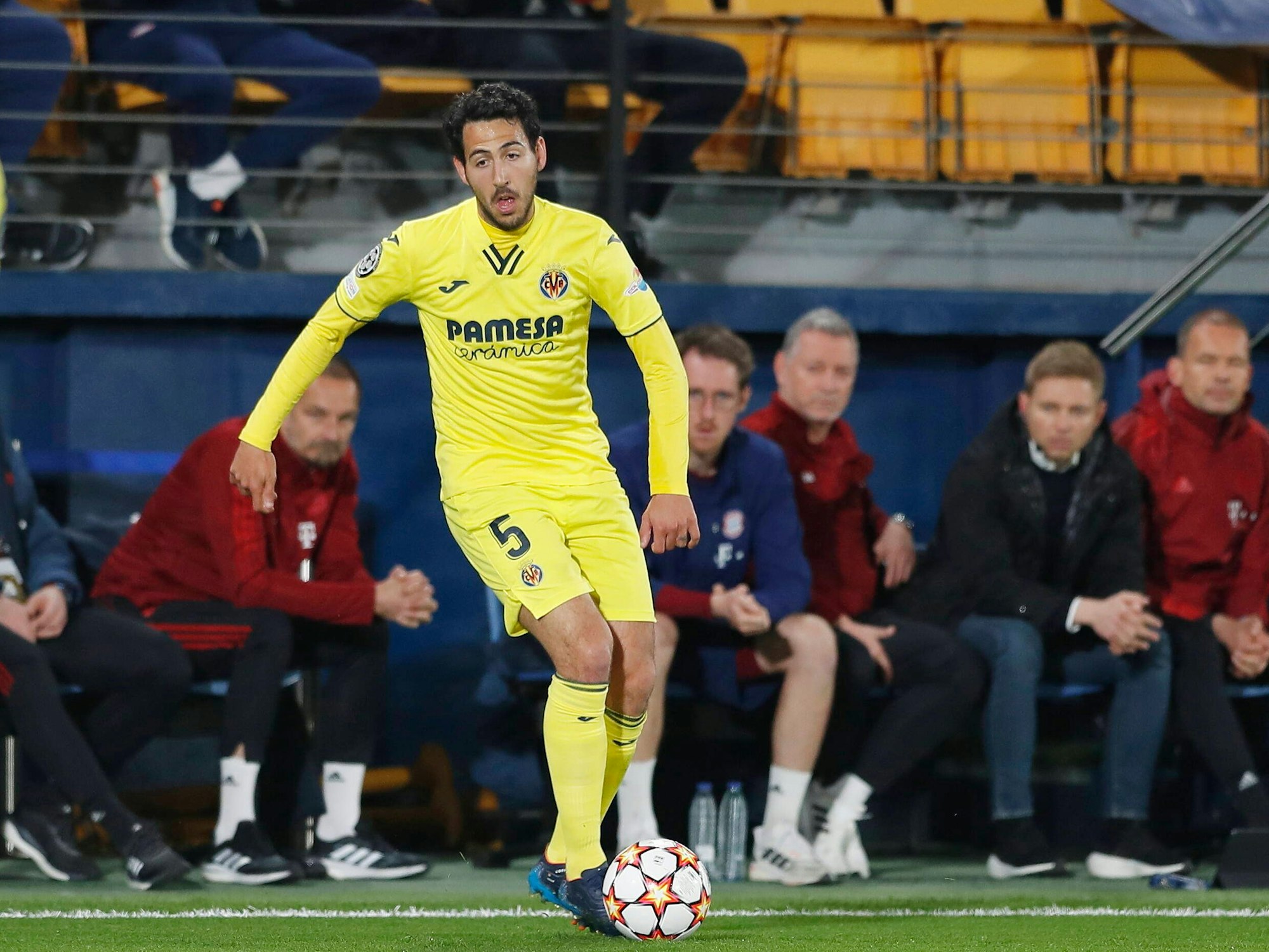 Dani Parejo im Hinspiel der Champions League am Ball. Hinter ihm sieht man die Bank des FC Bayern.