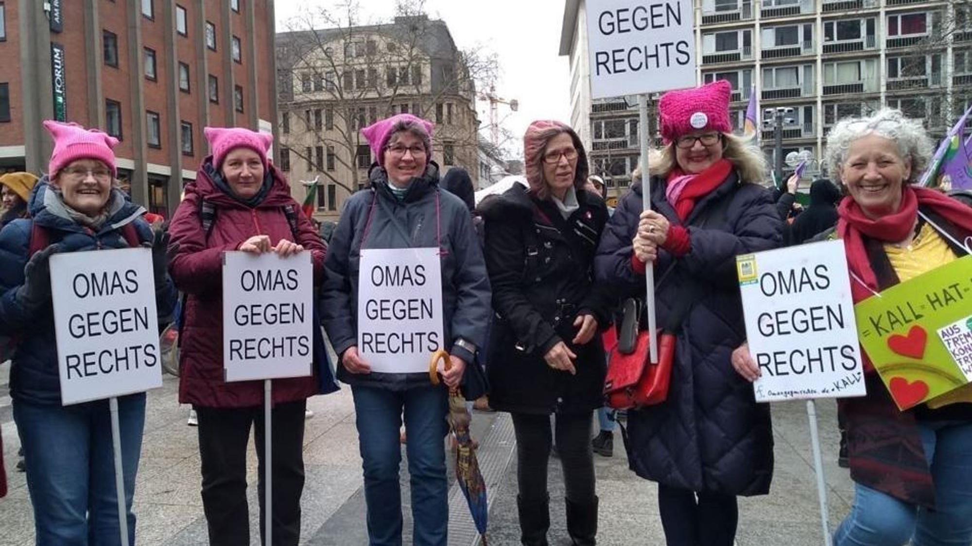 Sechs Frauen stehen mit Schildern auf der Domplatte in Köln.
