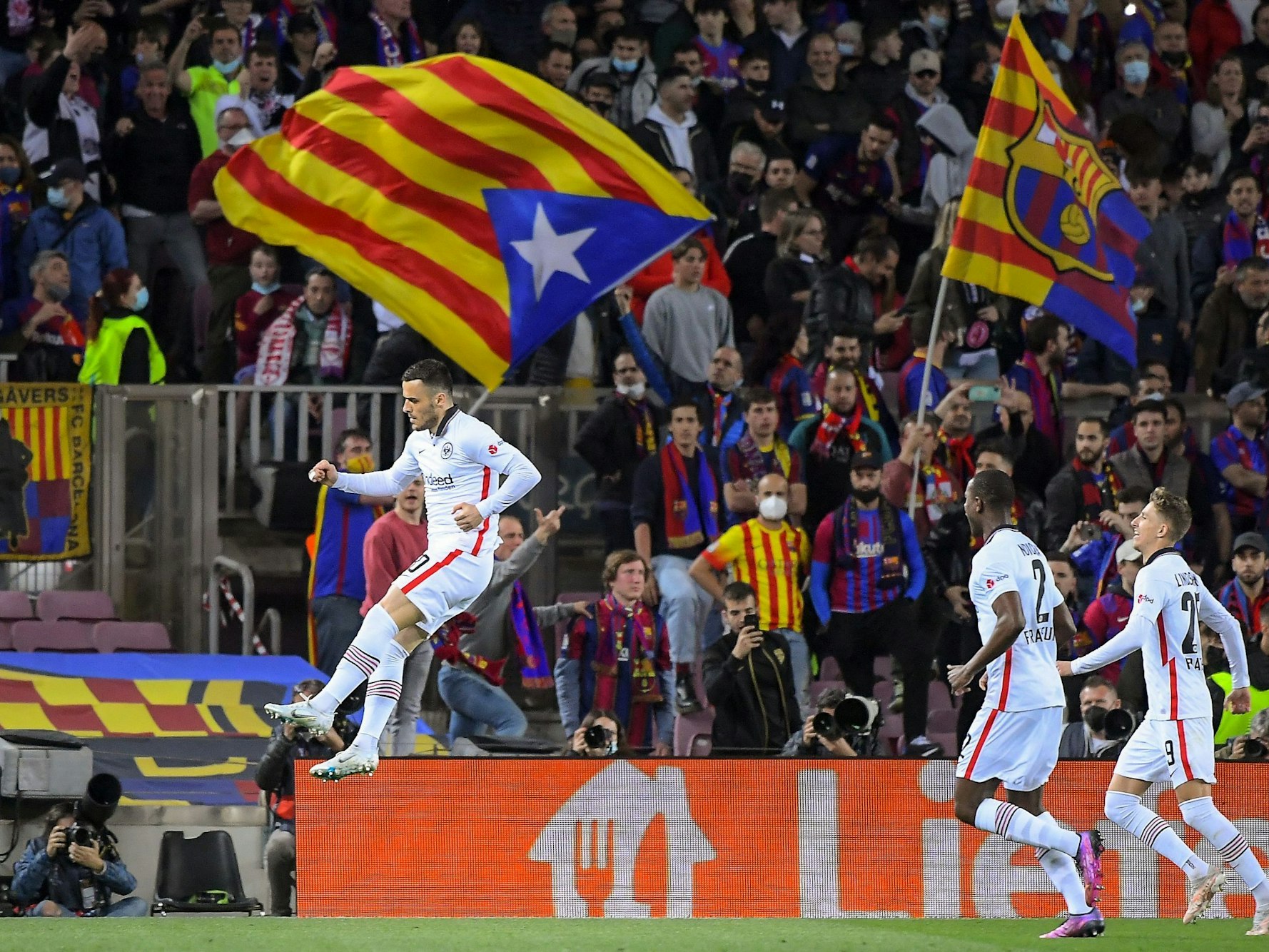 Eintracht Frankfurt's Serbian midfielder Filip Kostic (L) celebrates after scoring his team's first goal during the Europa League quarter final second leg football match between FC Barcelona and Eintracht Frankfurt at the Camp Nou stadium in Barcelona on April 14, 2022. (Photo by Jose Jordan / AFP)