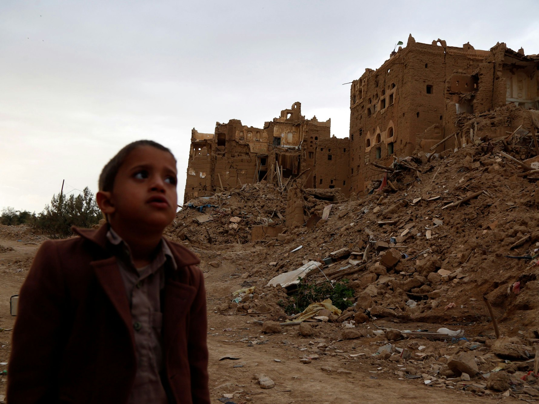 Ein Kind steht im März 2020 in der Nähe von Häusern, die während des anhaltenden Krieges in der Provinz Saada im Jemen durch Luftangriffe zerstört wurden.