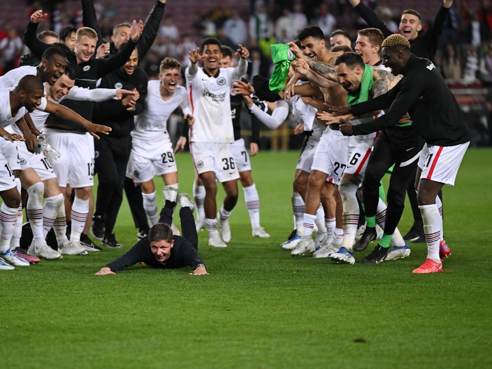 Frankfurts Cheftrainer Oliver Glasner (M) feiert mit der Mannschaft nach dem Schlusspfiff. Der Frankfurter Trainer schmiss sich nach dem Sieg auf den Rasen: Zack, war seine Hose kaputt.