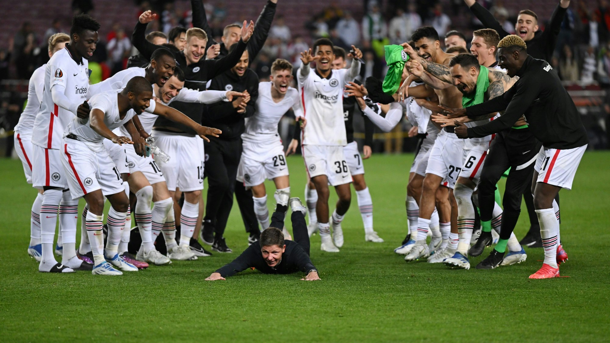 Frankfurts Cheftrainer Oliver Glasner (M) feiert mit der Mannschaft nach dem Schlusspfiff. Der Frankfurter Trainer schmiss sich nach dem Sieg auf den Rasen: Zack, war seine Hose kaputt.