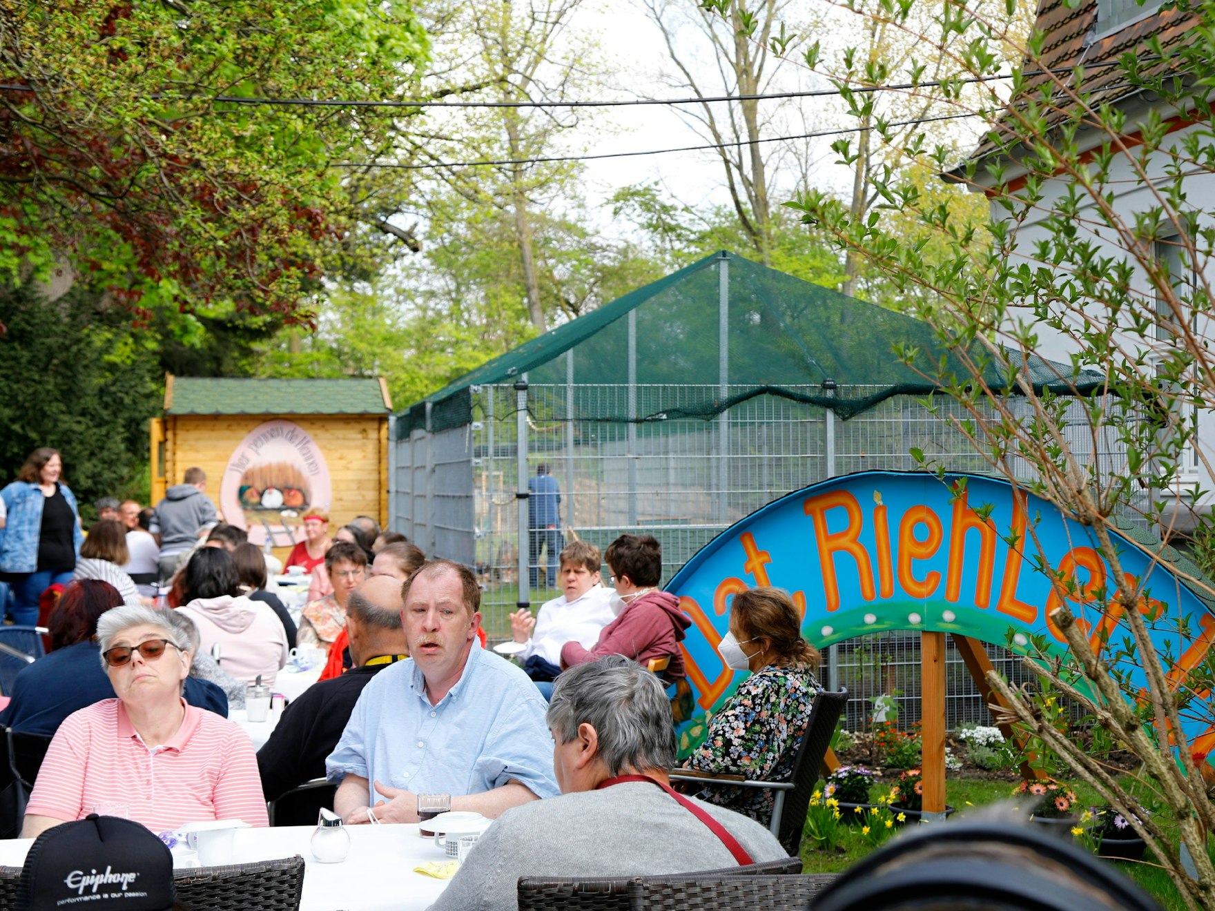 Menschen sitzen im Café Cultura, wo ein großer Hühnerstall in Sichtweite eröffnet wurde.