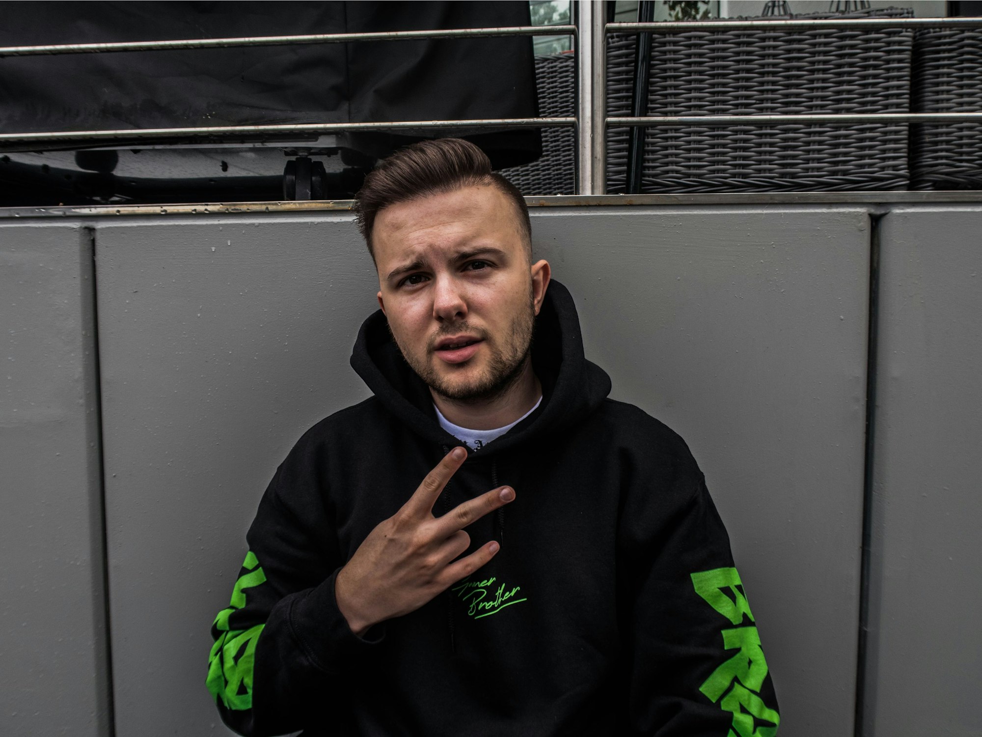 YouTuber Simon Schildgen hält zwei Finger zu einem Peace-Zeichen in die Kamera.