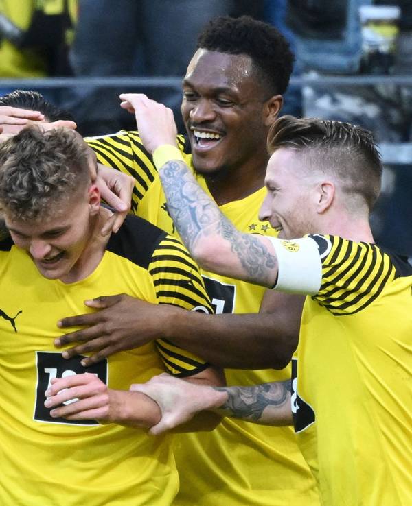 Tom Rothe wird von seinen BVB-Kollegen nach seinem Tor für Borussia Dortmund gegen den VfL Wolfsburg beglückwünscht.