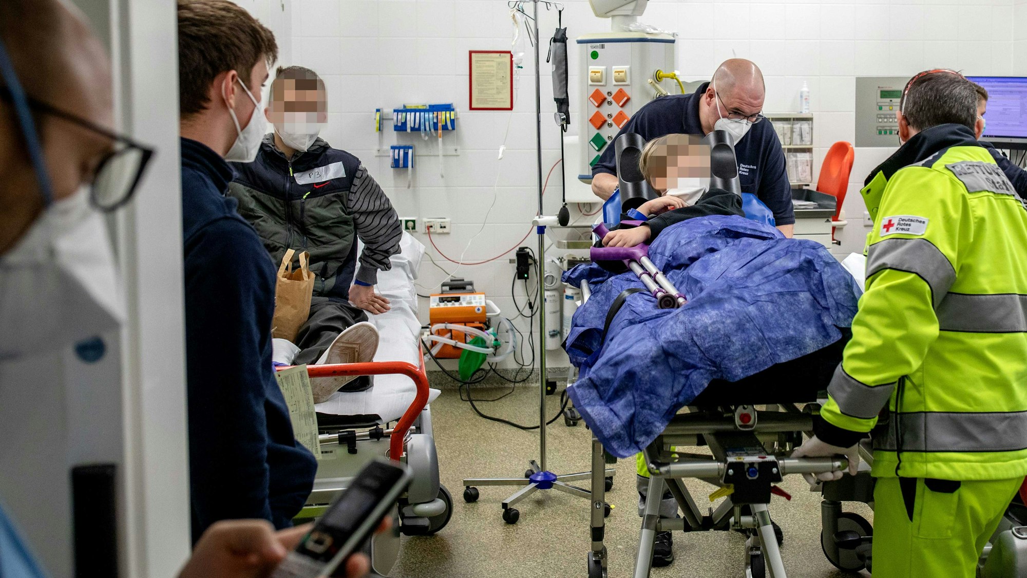 Ein Kleinkind und sein größerer Bruder liegen im Notfallzentrum auf Krankentragen und werden erstversorgt.