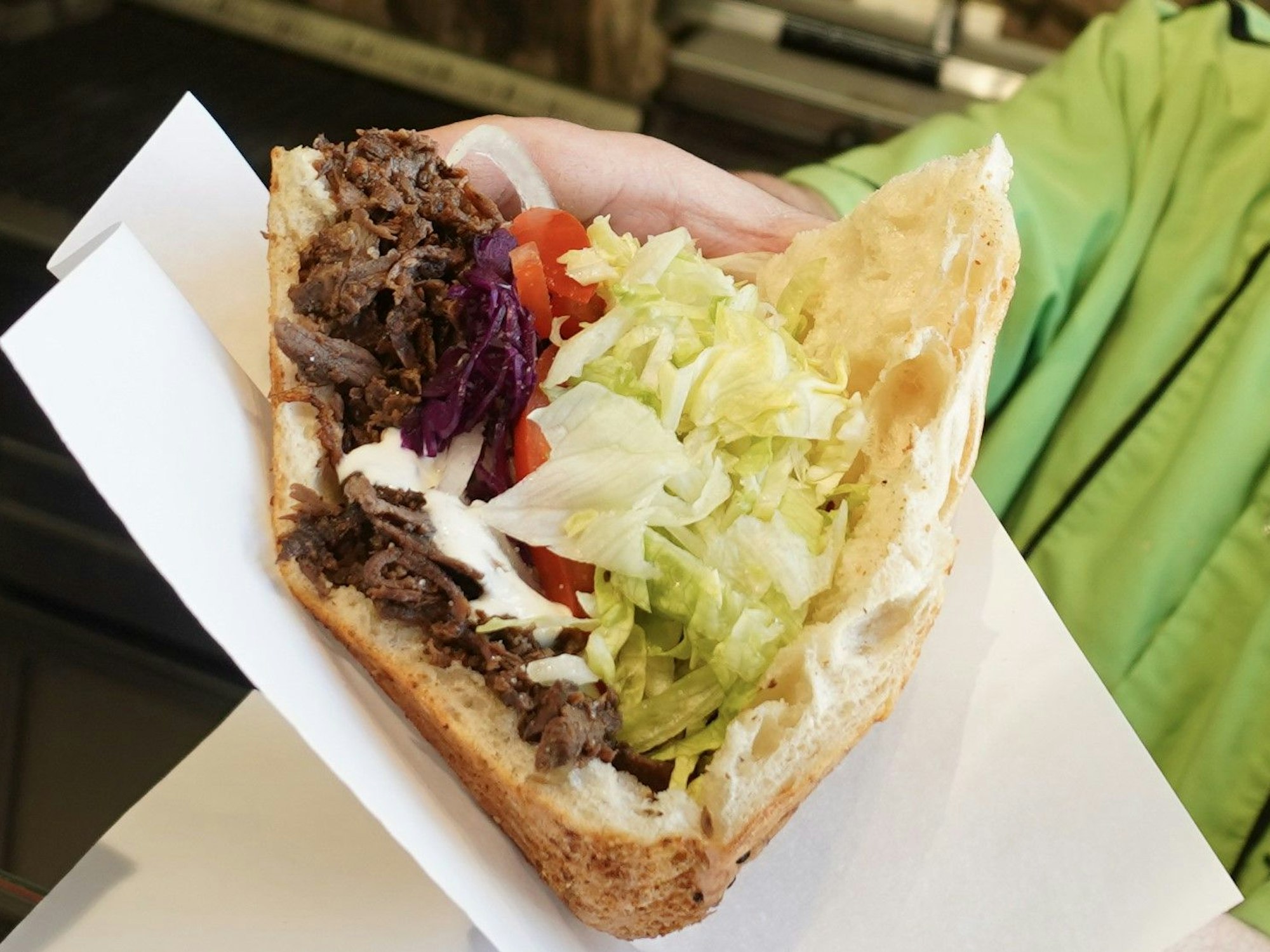 Ein Mitarbeiter bei der Zubereitung eines Döners. Döner wird in Köln teurer. Experten befürchten sogar ein Imbiss-Sterben.