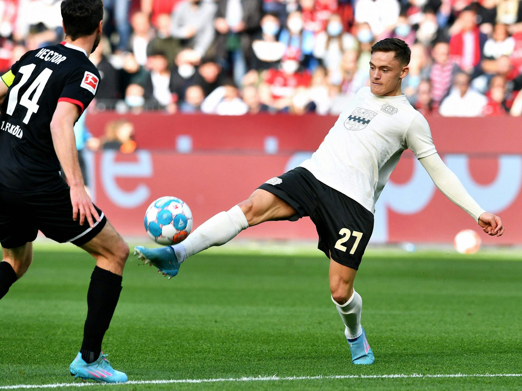 Leverkusens Florian Wirtz (rechts) behauptet den Ball gegen Kölns Kapitän Jonas Hector.