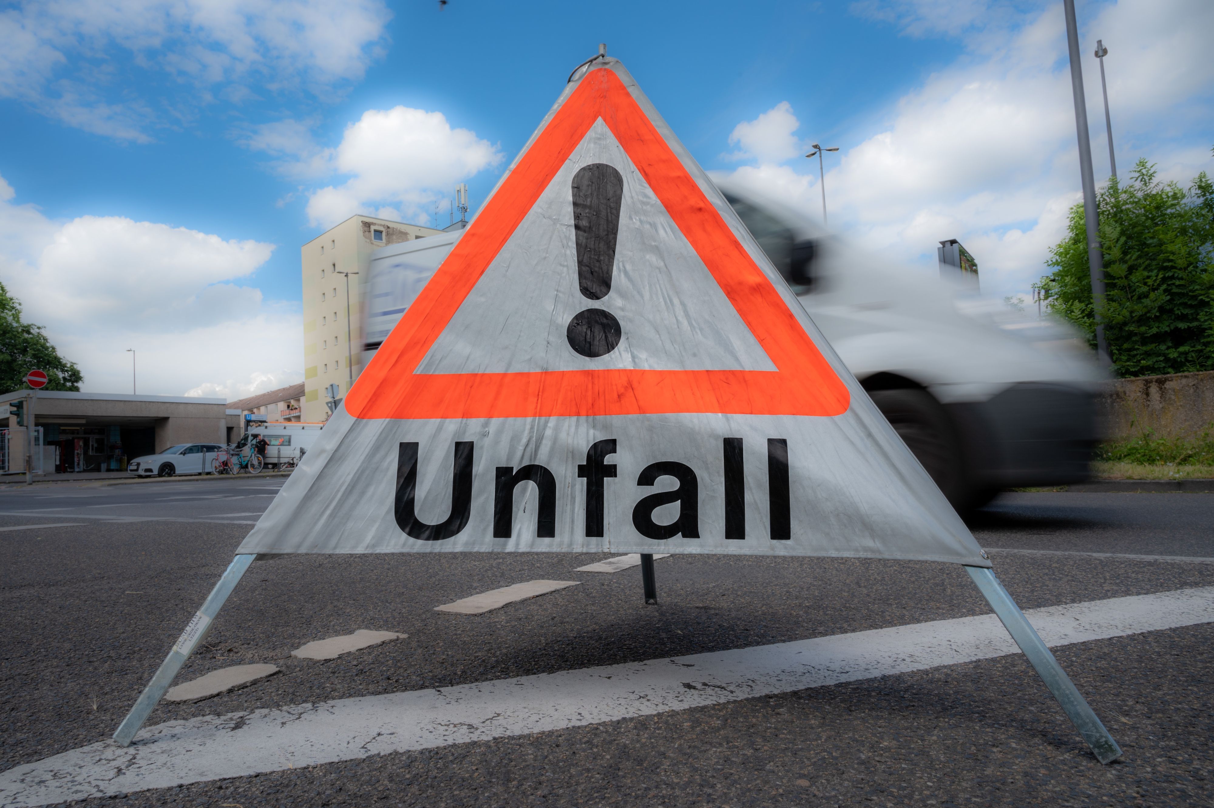 Das Foto zeigt ein mobiles Schild der Polizei mit der Aufschrift „Unfall“. Nach einem Unfall auf der Dürener Straße ist die Beifahrerin im Krankenhaus verstorben. Der Unfall passierte am 15. April 2022).