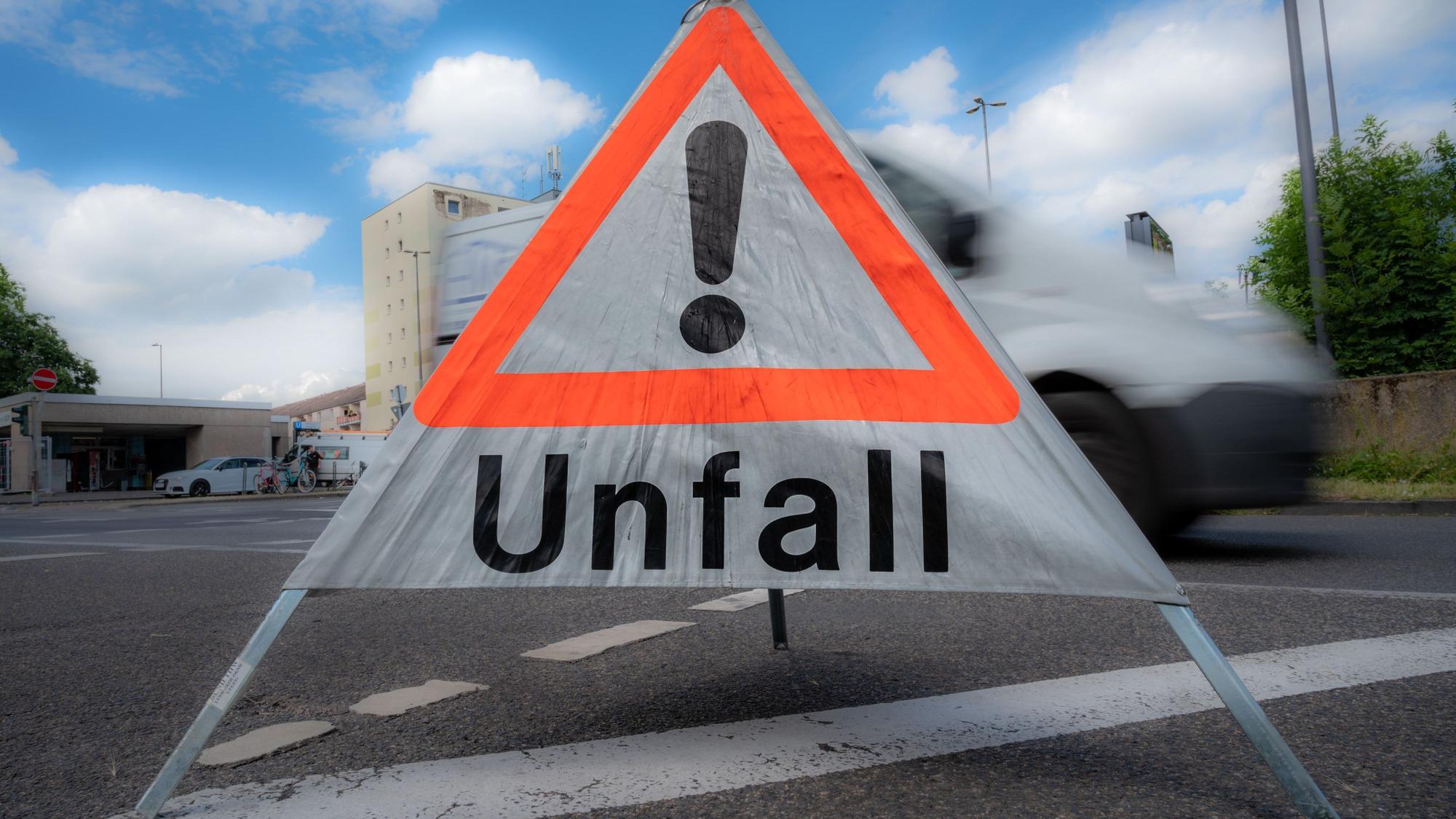 Das Foto zeigt ein mobiles Schild der Polizei mit der Aufschrift „Unfall“. Nach einem Unfall auf der Dürener Straße ist die Beifahrerin im Krankenhaus verstorben. Der Unfall passierte am 15. April 2022).