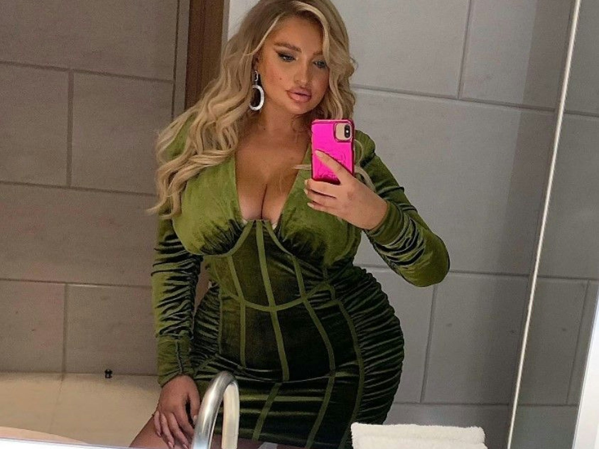 Sarina Nowak posiert in einem samtgrünen Kleid für ein Selfie.