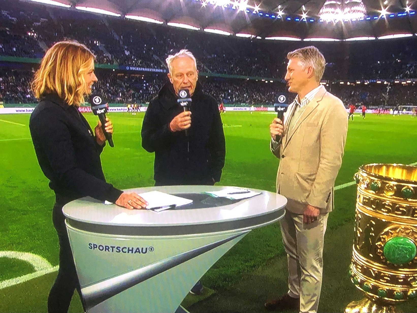 DFB-Pokal-Halbfinale: Christian Streich (SC Freiburg, Mitte) am 19. April 2022 im Interview mit ARD-Moderatorin Jessy Wellmer und Experte Bastian Schweinsteiger in Hamburg.
