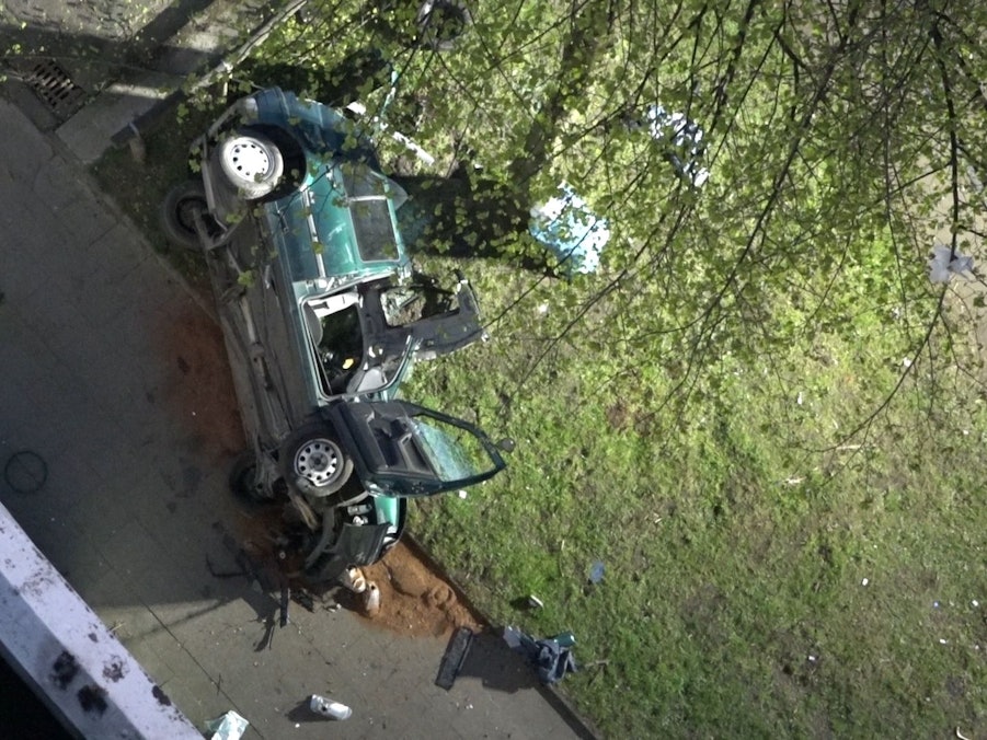 Das Wrack eines Autos liegt neben einem Parkhaus. Zwei junge Männer sind am Ostersonntag in Essen mit einem Auto aus der obersten Etage eines Parkhauses gestürzt und ums Leben gekommen.