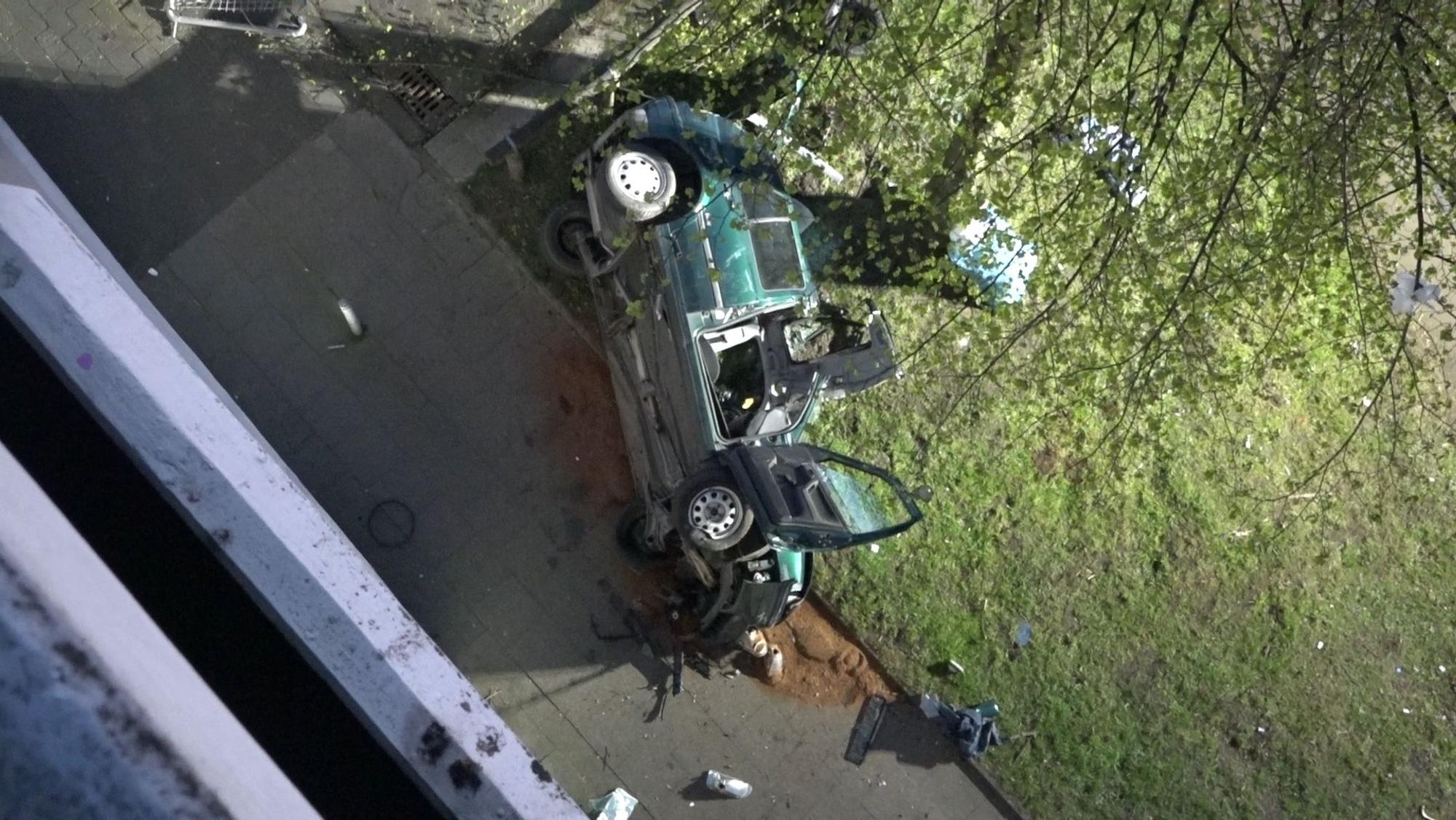 Das Wrack eines Autos liegt neben einem Parkhaus. Zwei junge Männer sind am Ostersonntag in Essen mit einem Auto aus der obersten Etage eines Parkhauses gestürzt und ums Leben gekommen.