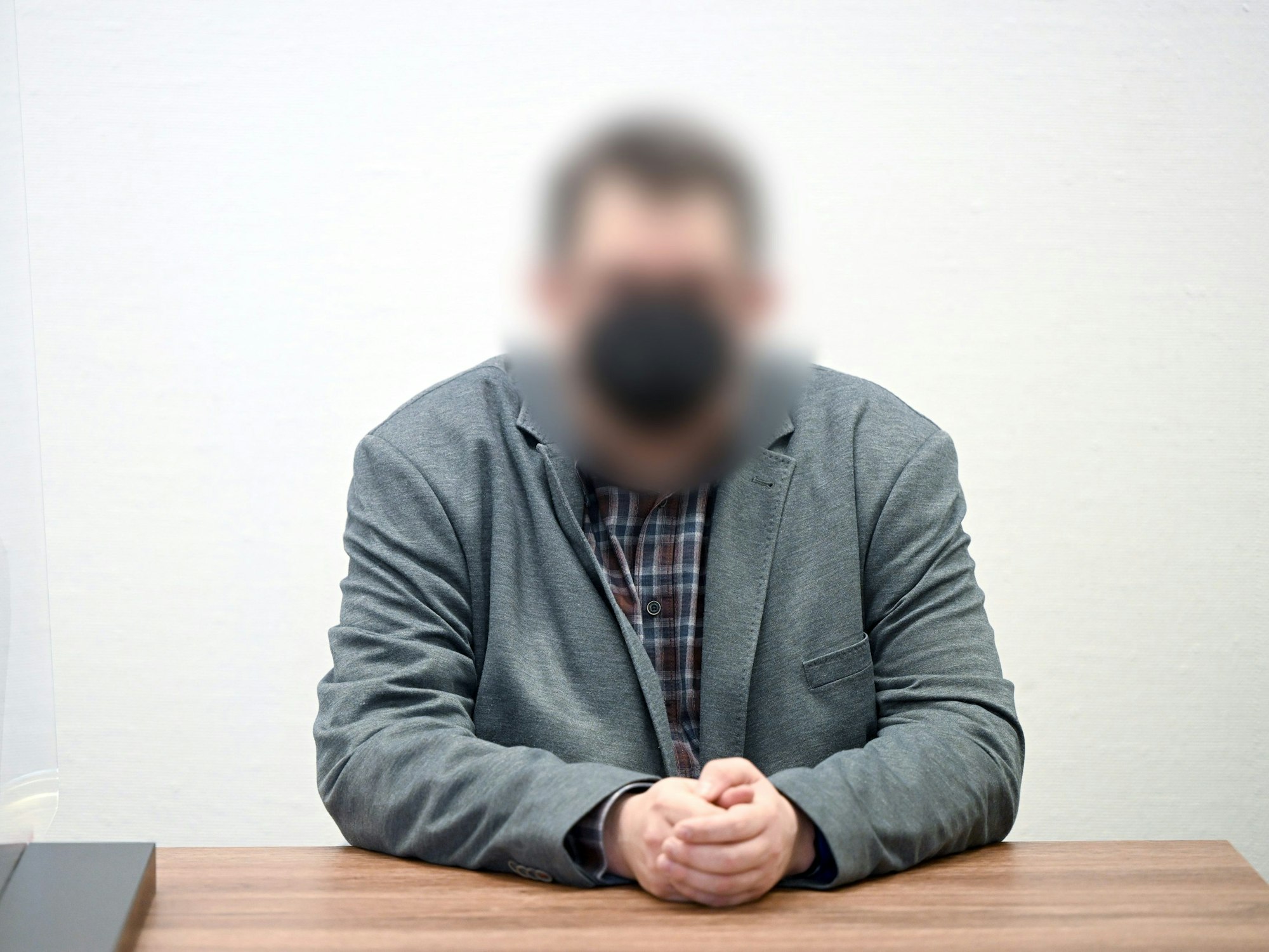 Der Angeklagte sitzt vor dem Beginn des Prozesses im Gerichtssaal im Landgericht. Der ehemalige Kölner Schwimmtrainer soll sich in sieben Fällen an Kindern sexuell vergangen haben.