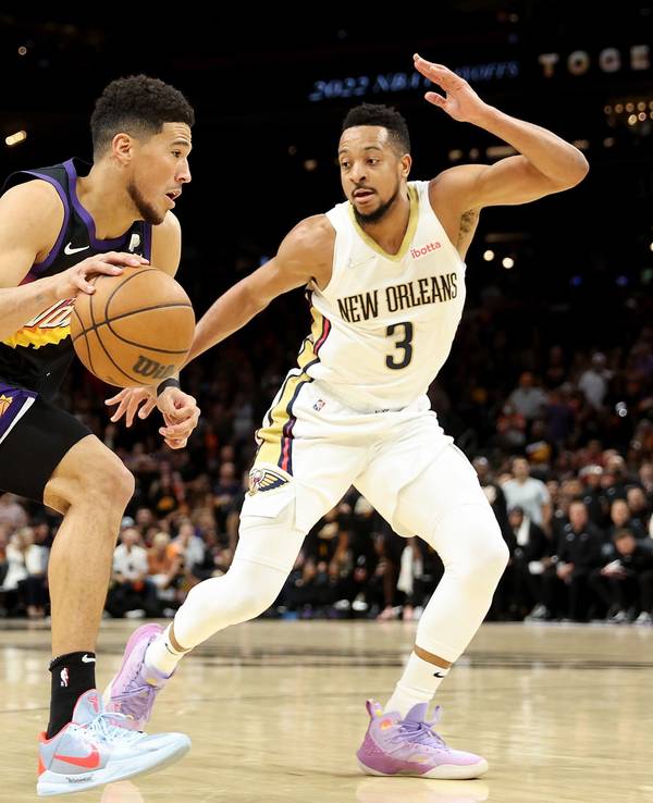 Devin Booker von den Phoenix Suns (links) zieht an CJ McCollum von den New Orleans Pelicans vorbei.