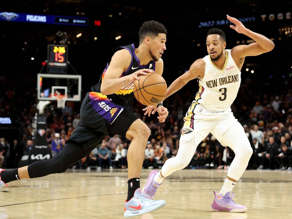 Devin Booker von den Phoenix Suns (links) zieht an CJ McCollum von den New Orleans Pelicans vorbei.