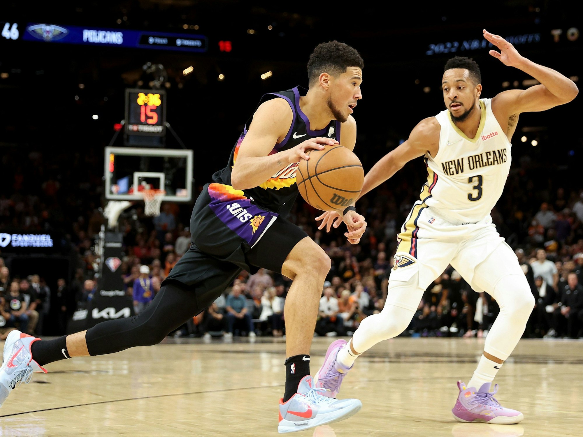 Devin Booker von den Phoenix Suns (links) zieht an CJ McCollum von den New Orleans Pelicans vorbei.