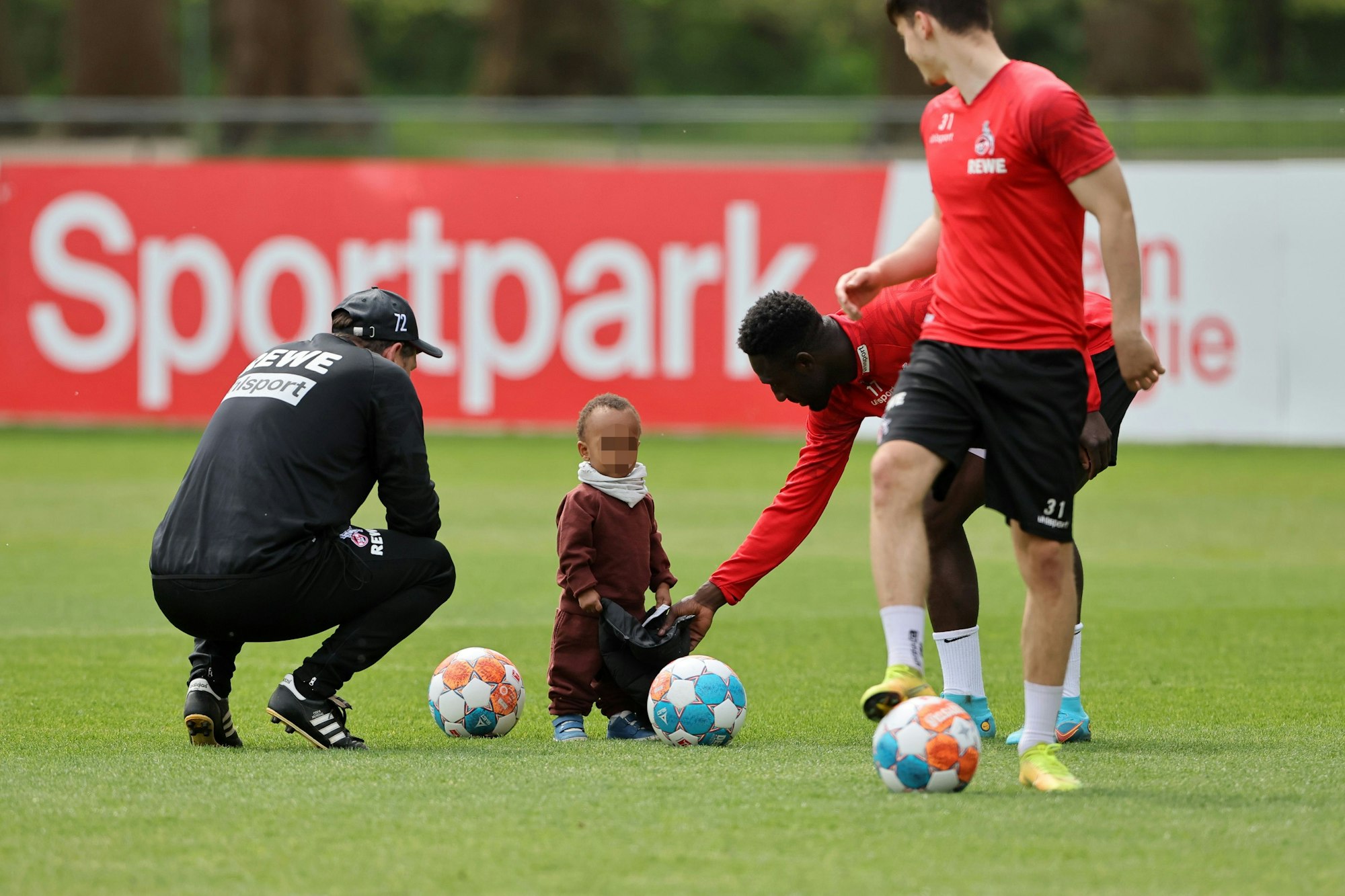 Kingsley Schindler spielt beim Mannschaftstraining des 1. FC Köln mit seinem Sohn.