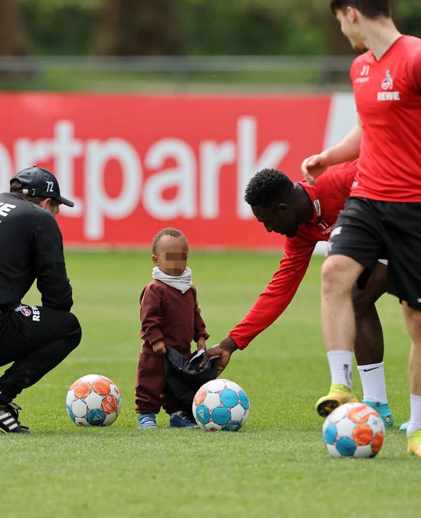 Kingsley Schindler spielt beim Mannschaftstraining des 1. FC Köln mit seinem Sohn.