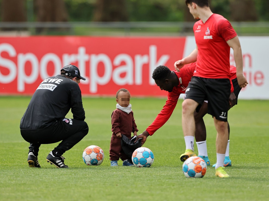 Kingsley Schindler spielt beim Mannschaftstraining des 1. FC Köln mit seinem Sohn.