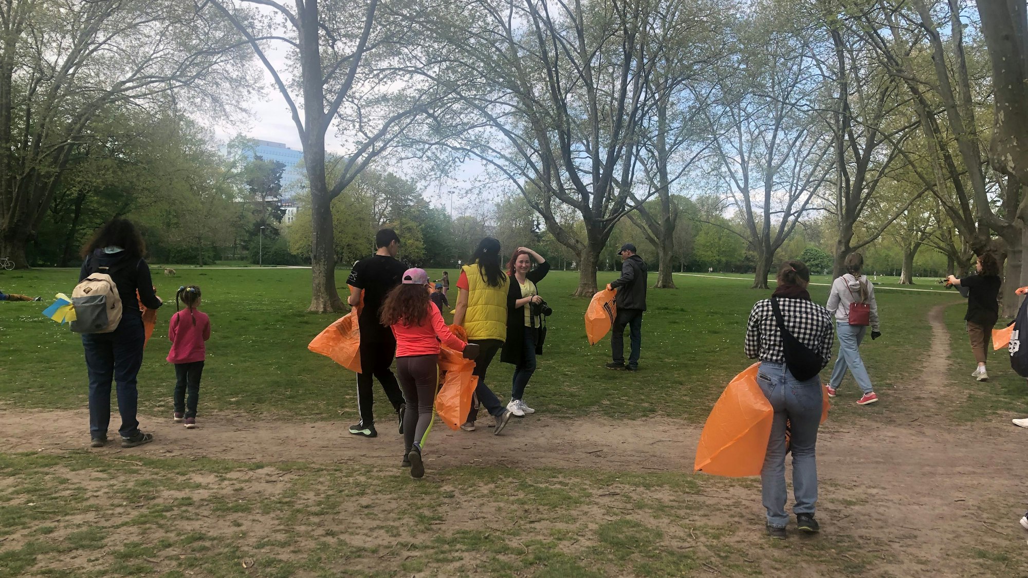 Ukrainische Geflüchtete bei einer Aufräumaktion im Park in Köln