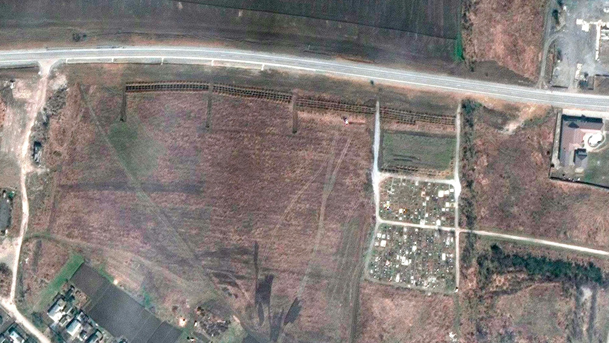 Das neue Satellitenfoto soll ein Massengrab in Manhusch (parallel zum Straßenverlauf) zeigen, das rund 20 Kilometer westlich von Mariupol liegt. Es wurde am 21. April veröffentlicht.
