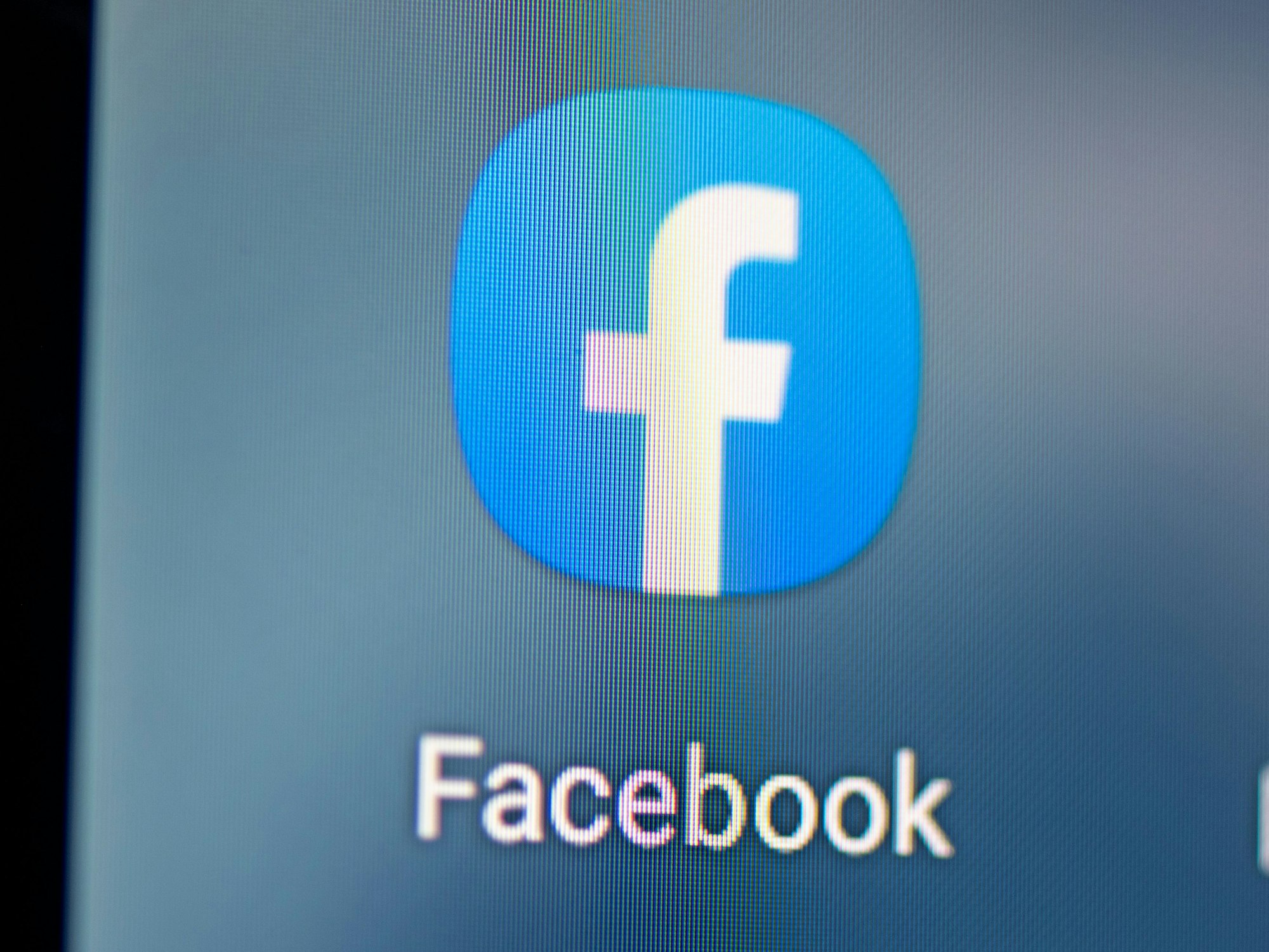 Auf dem Bildschirm eines Smartphones sieht man das Logo der App Facebook. Das Symbolbild ist vom 28. April 2021.
