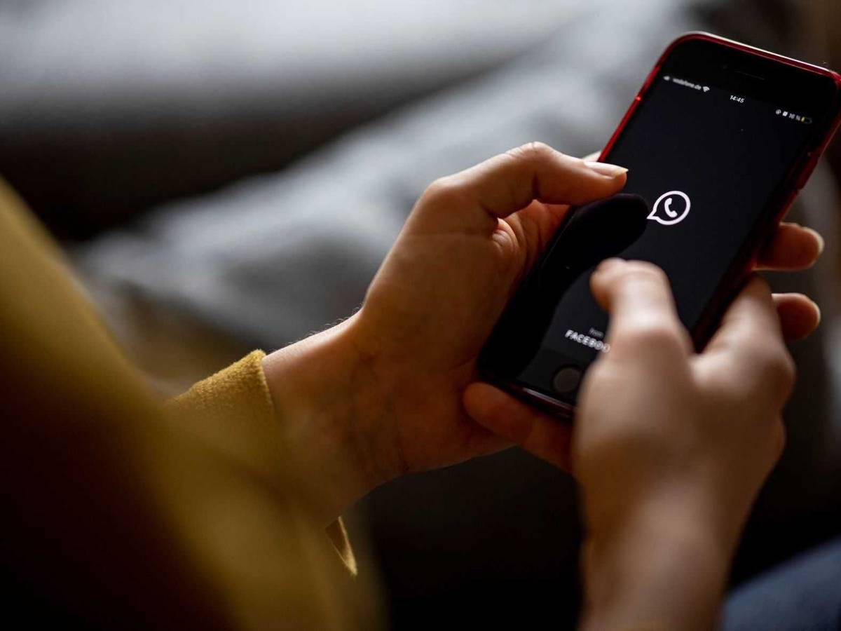 Auf dem Bildschirm eines Smartphones sieht man das Logo der App Whatsapp.