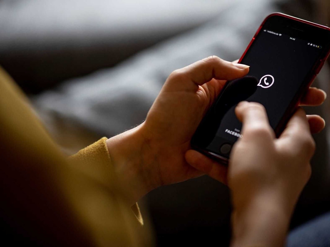 Auf dem Bildschirm eines Smartphones sieht man das Logo der App Whatsapp.