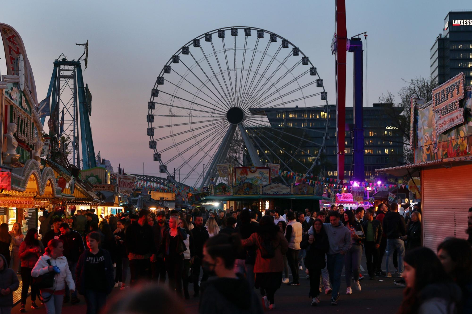 Menschen gehen über die Deutzer Kirmes in Abendstimmung