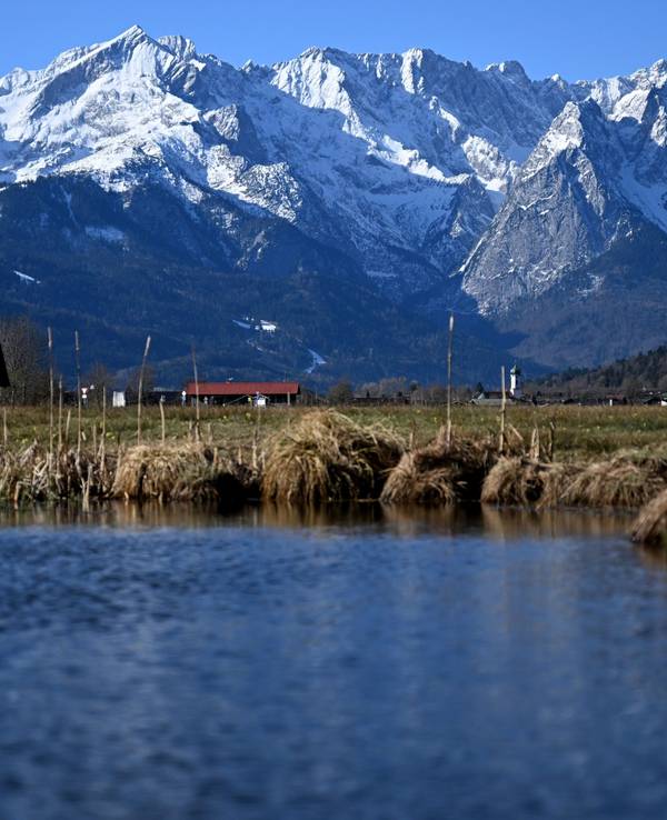 See, Wiese, ein Häuschen und Berge in Garmisch-Partenkirchen (Bayern).