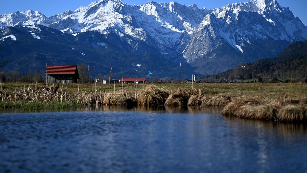 See, Wiese, ein Häuschen und Berge in Garmisch-Partenkirchen (Bayern).