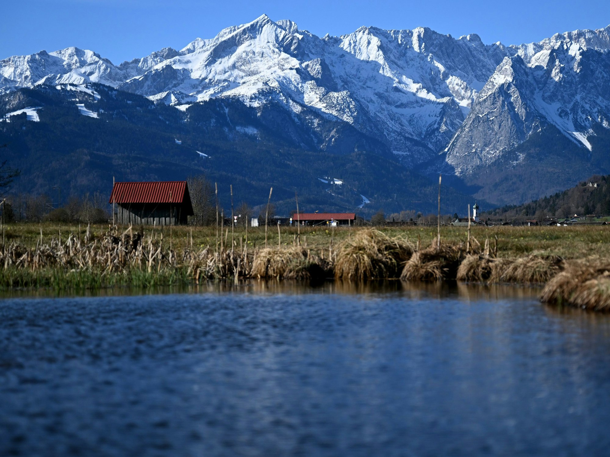 See, Wiese, ein Häuschen und Berge in Garmisch-Partenkirchen (Bayern).
