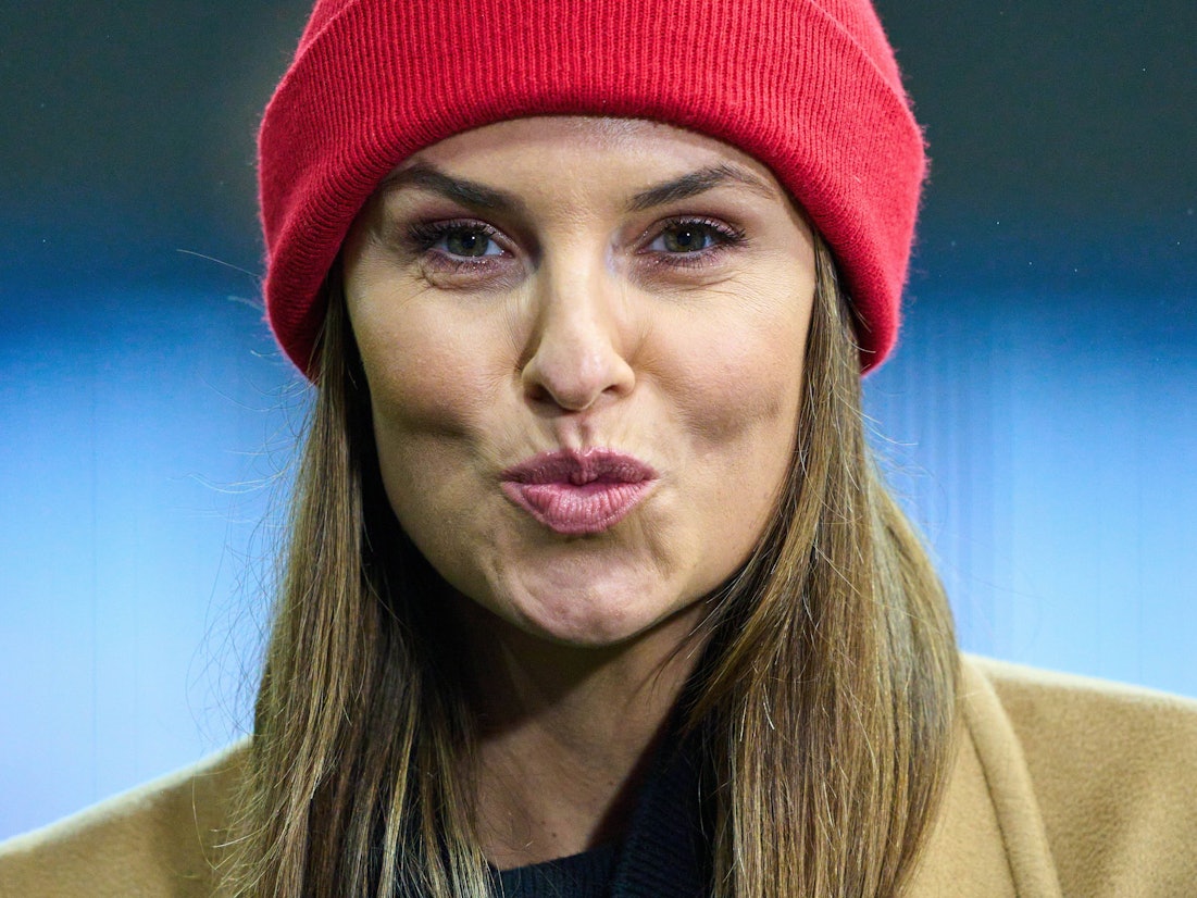 Laura Wontorra formt bei einem Bundesliga-Spiel einen Kuss-Mund in die Kamera.