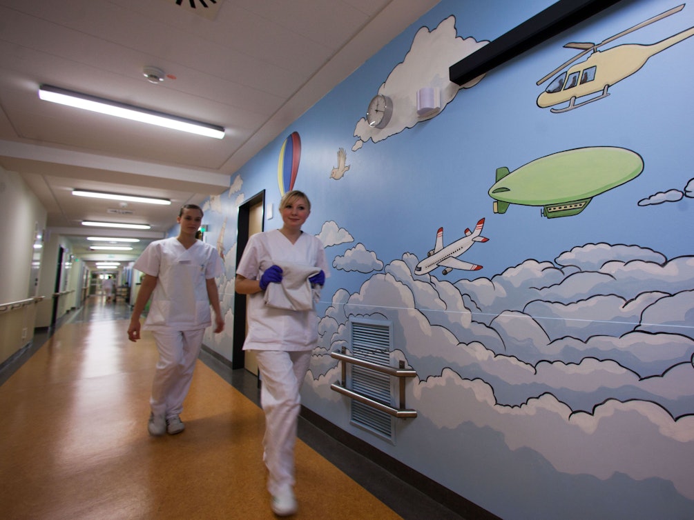 Zwei Krankenschwestern laufen am 13. Dezemeber 2011 an einem großen Wandbild auf einer Station vorbei.