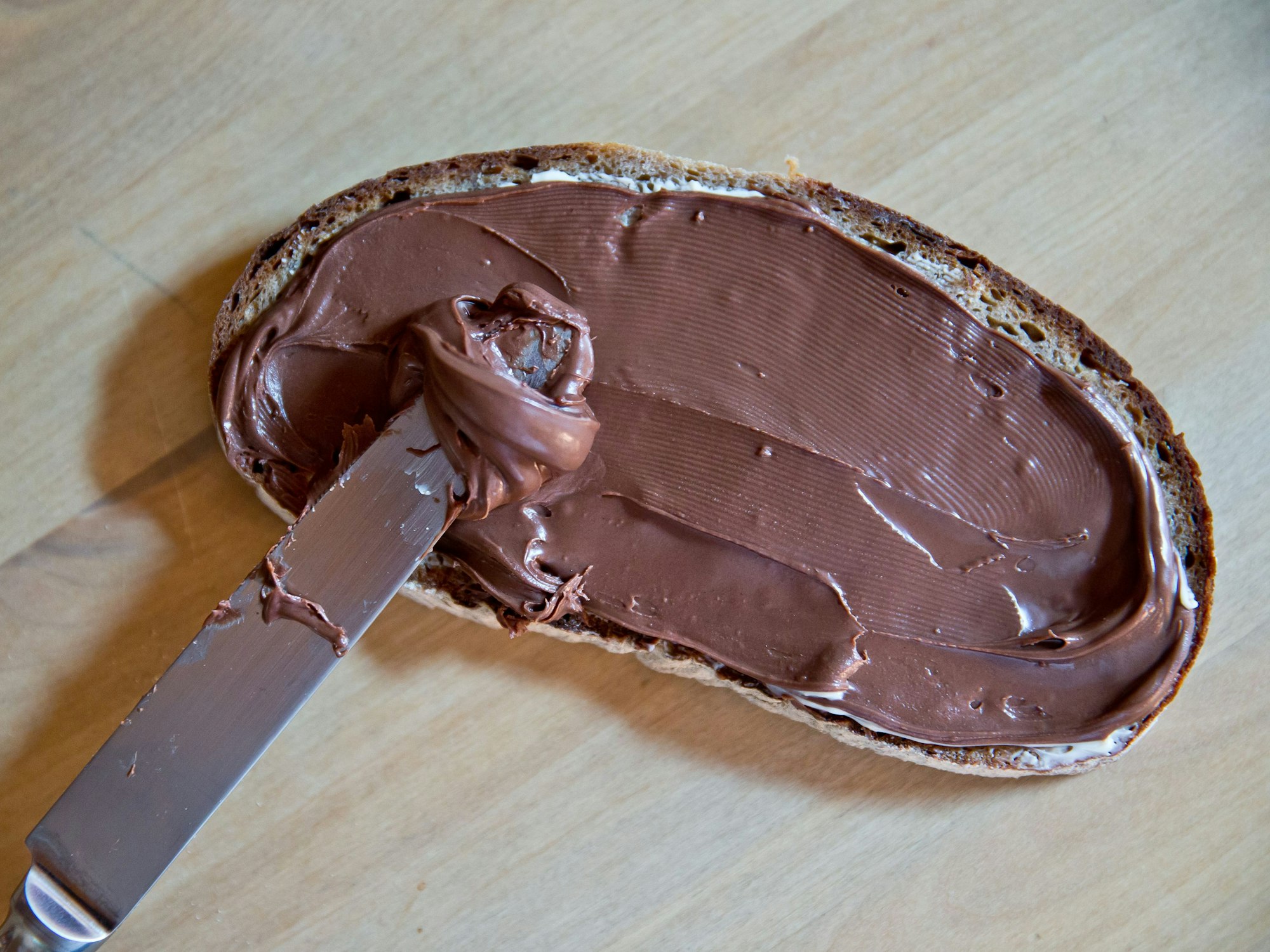 Rückruf bei Aldi: Es geht um eine beliebte Brotsorte, vor der gewarnt wird. Unser Symbolfoto wurde 2013 geschossen. ARCHIV - Eine Scheibe Schwarzbrot mit Butter und Nutella, aufgenommen am 15.04.2013 in Nürnberg (Bayern). (zu "Nutella wird heller - Mehr Zucker, weniger Kakao" vom 06.11.2017) Foto: Daniel Karmann/dpa +++ dpa-Bildfunk +++