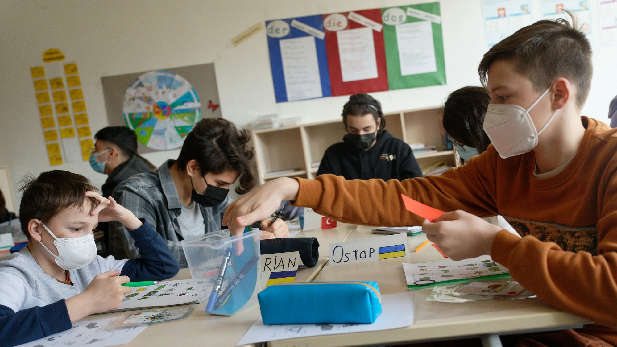 Schülerinnen und Schüler arbeiten in einer Klasse an ihren Aufgaben.