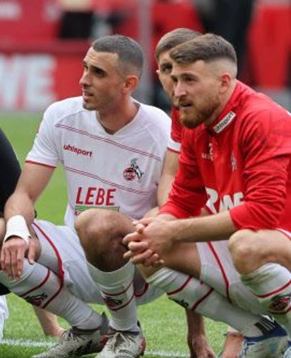 Marvin Schwäbe (l.) kniet mit Ellyess Skhiri, Jeff Chabot und Salih Özcan auf dem Boden.