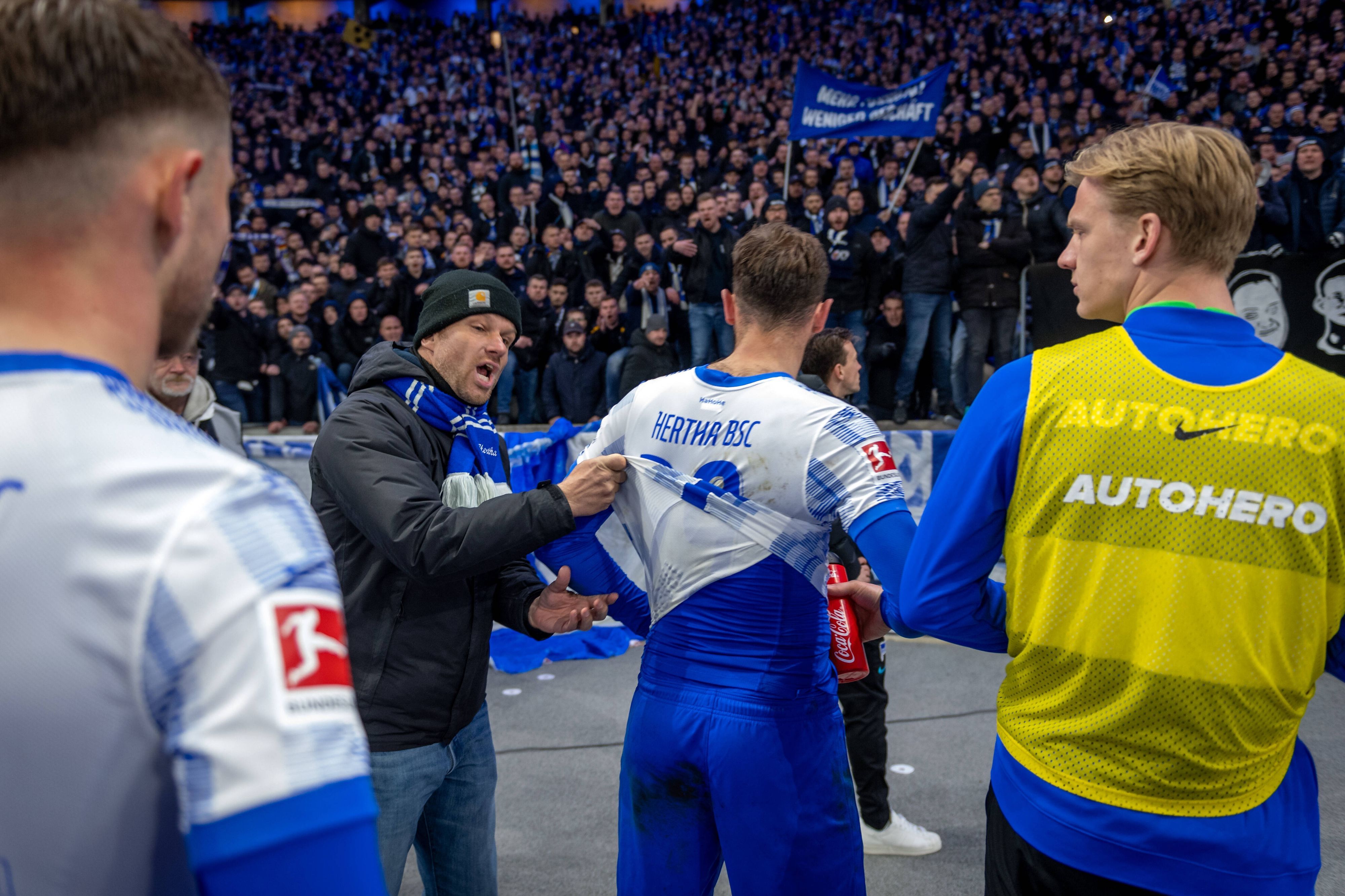 Niedergeschlagene Hertha-Spieler nach der Niederlage gegen Union vor der Kurve.
