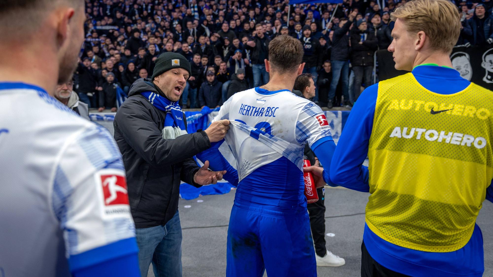 Niedergeschlagene Hertha-Spieler nach der Niederlage gegen Union vor der Kurve.