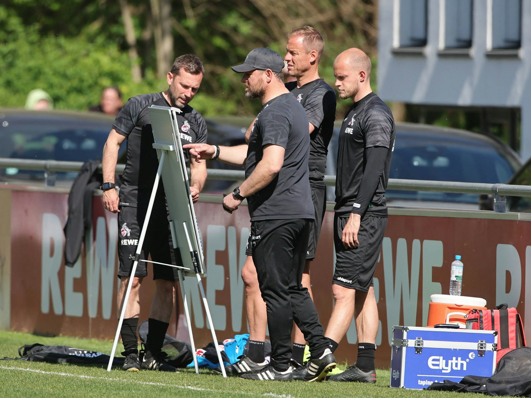 Das Trainerteam des 1. FC Köln studiert die Taktik-Tafel.