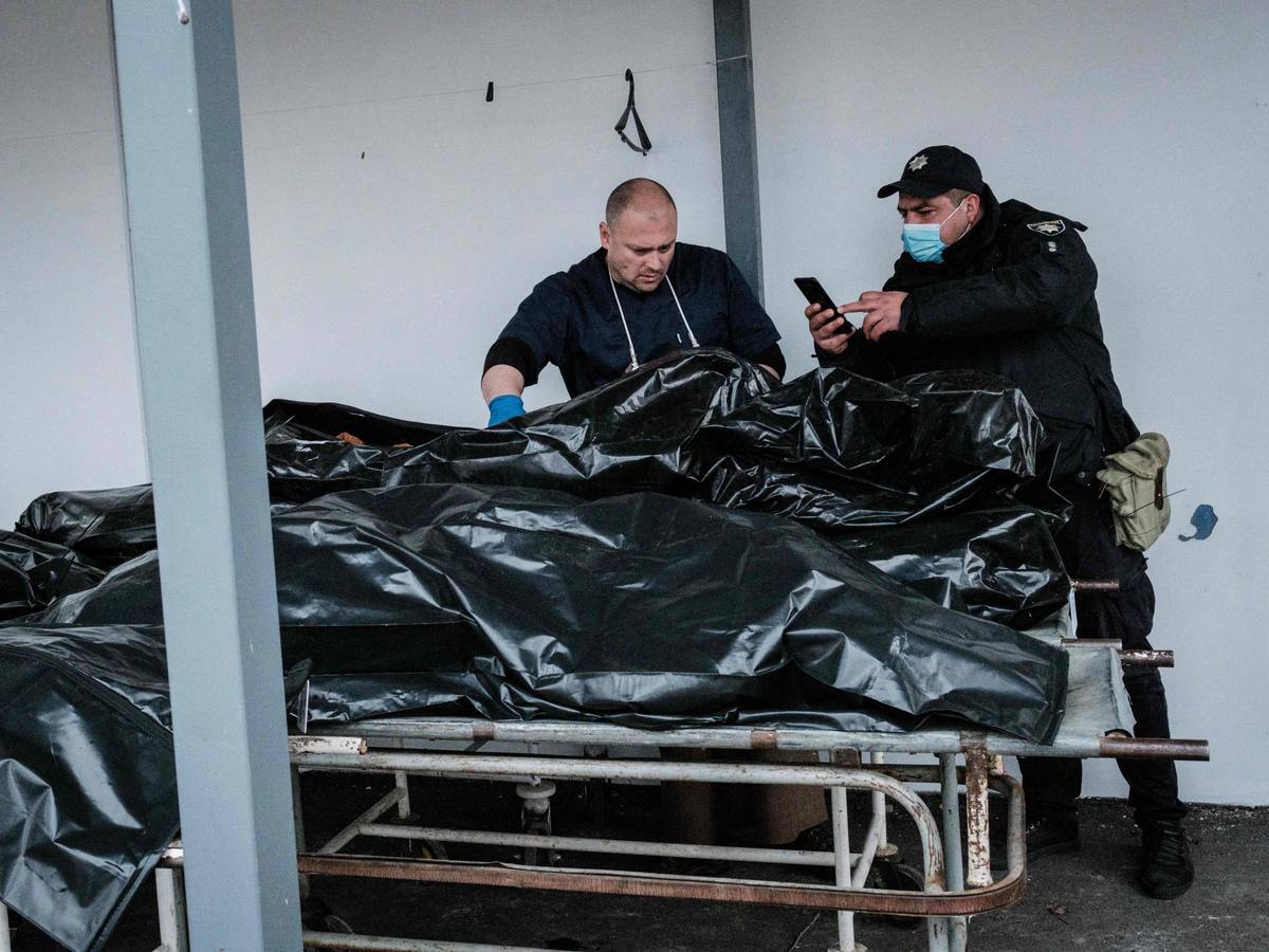 Polizeibeamte fotografieren am 18. April für Ermittlungen einen der Toten, die in Butscha gefunden worden sind. Russischen Streitkräften wird vorgeworfen, in der Stadt zahlreiche Kriegsverbrechen begangen zu haben.