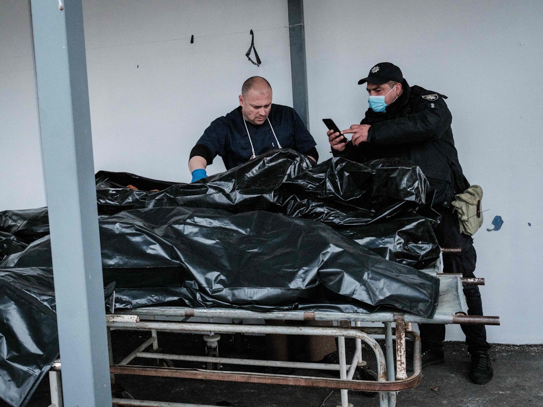 Polizeibeamte fotografieren am 18. April für Ermittlungen einen der Toten, die in Butscha gefunden worden sind. Russischen Streitkräften wird vorgeworfen, in der Stadt zahlreiche Kriegsverbrechen begangen zu haben.