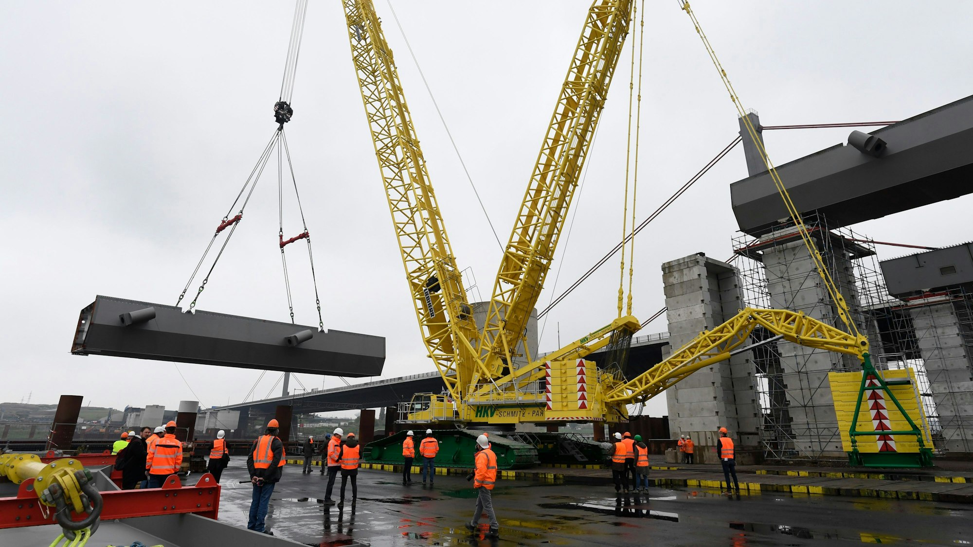 Ein Schwerlastkran hebt ein Stahl-Brückenteil