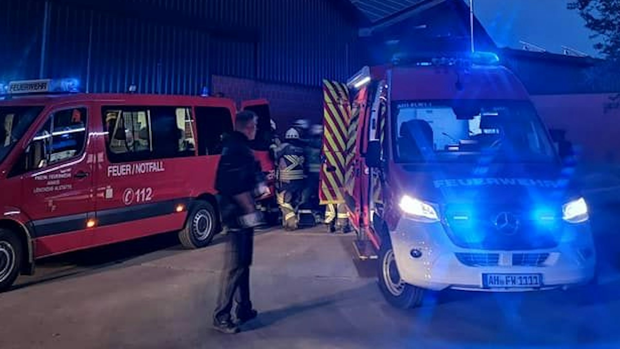 Feuerwehrkräfte laden Equipment aus einem Fahrzeug.