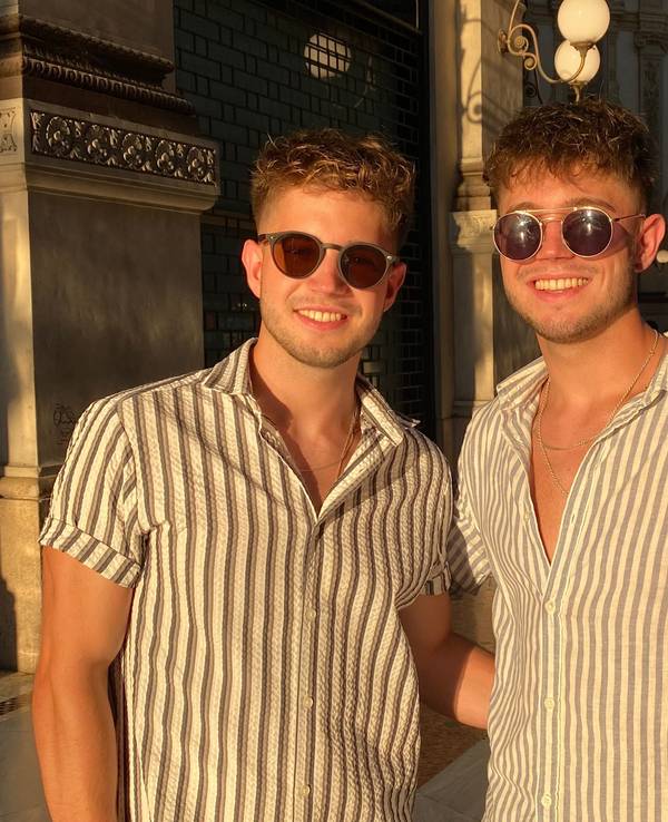 Roman und Nikita Kiselev schauen nebeneinander mit Sonnenbrillen in die Kamera.